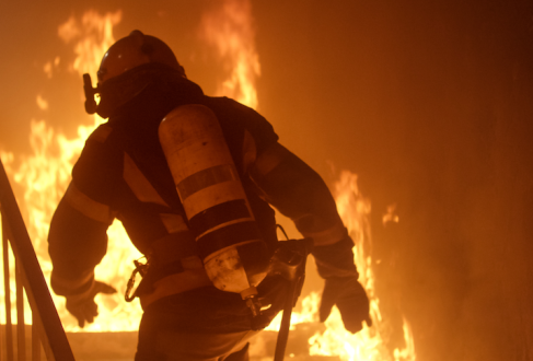 Firefighter going up burning stairs