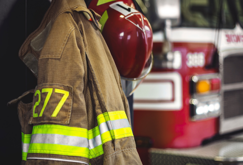 Firefighter uniform with firetruck in the background